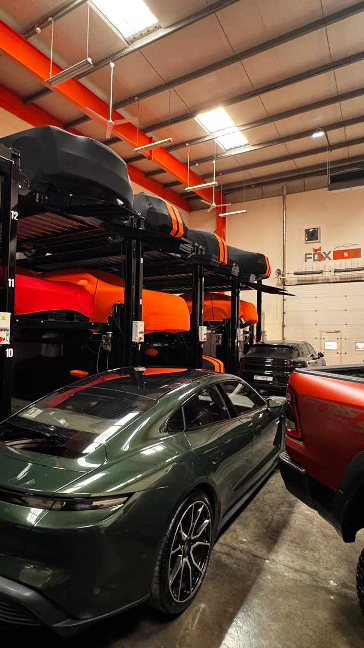 Green Porsche Taycan by the car lifts